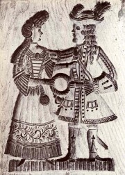 Het_echtpaar_op_deze_koekplank_houdt_een_ring_vast_als_huwelijkssymbool